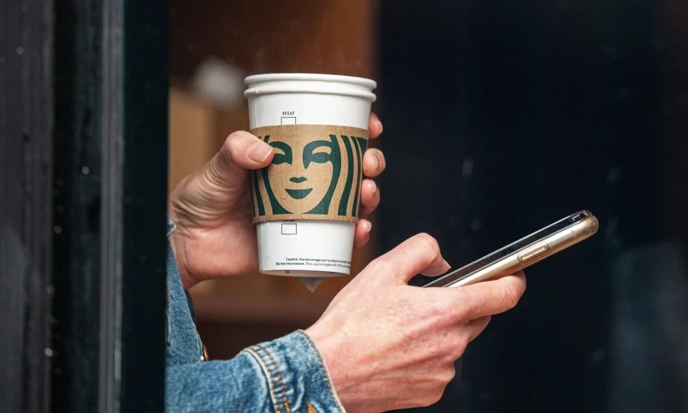 person holding starbucks cup