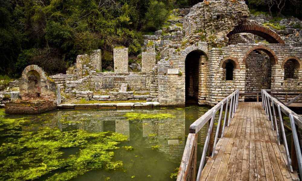 Old stone ruins connected by a bridge over water