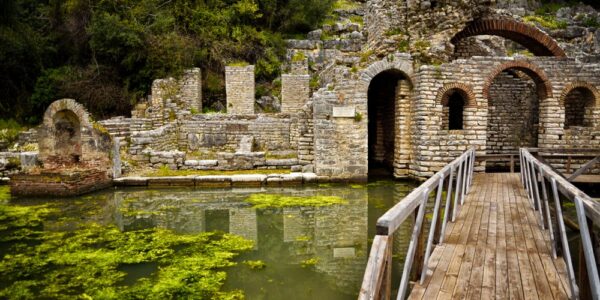 Old stone ruins connected by a bridge over water