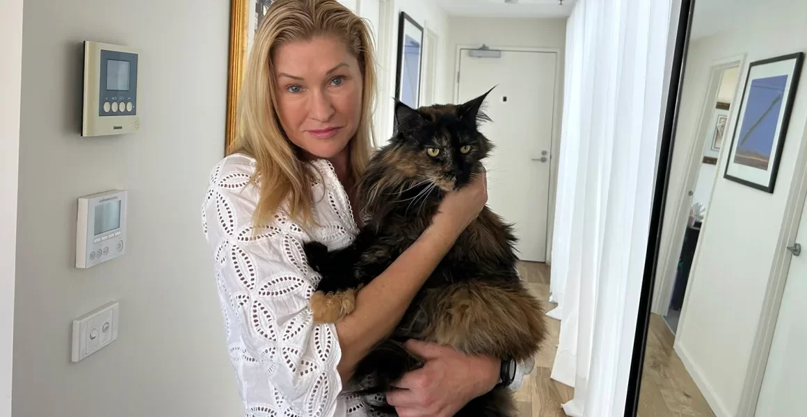 Woman holds her Maine coon cat.