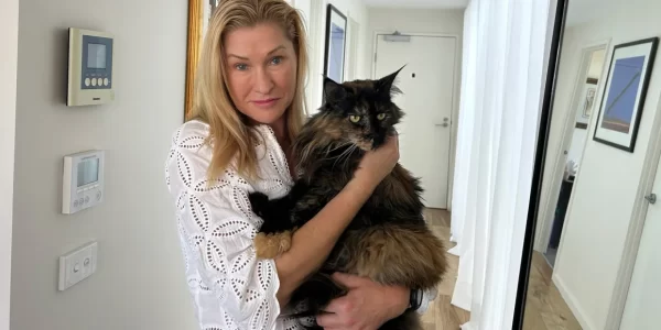 Woman holds her Maine coon cat.