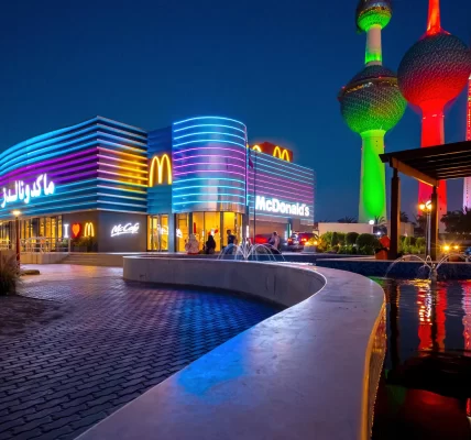 Outdoor shot of McDonald's in Kuwait City with neon blue and purple lights striped around the building