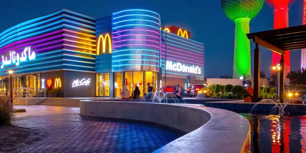 Outdoor shot of McDonald's in Kuwait City with neon blue and purple lights striped around the building