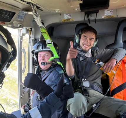 Rescued hiker on plane with first responders.