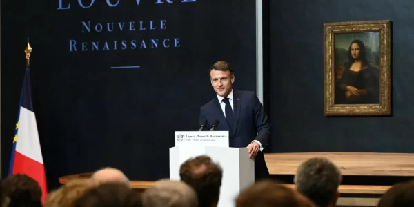 French president giving a speech in front of the Mona Lisa in the Louvre.