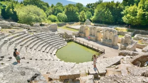 Stone ruins of an ancient amphitheater with tourists