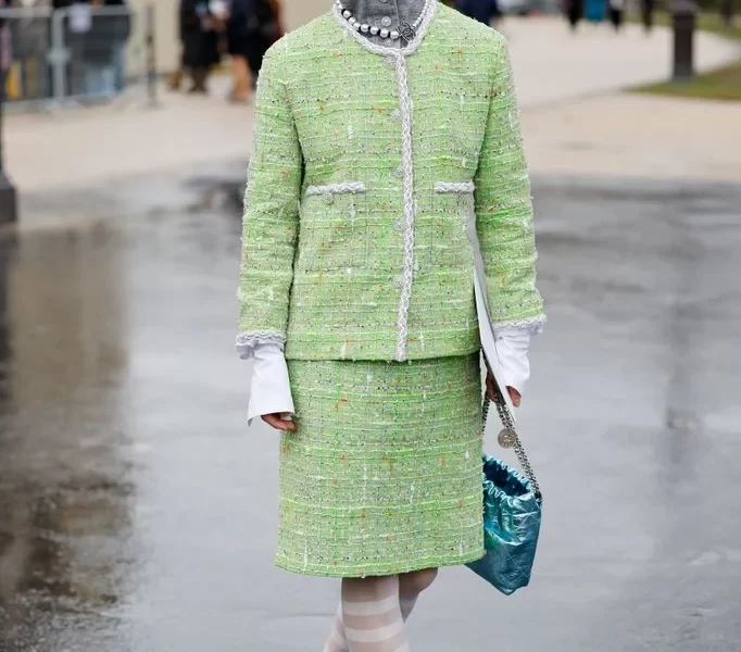 Yaqian Lan Donning winter 2025's most trending accessory- a knitted hood with a matching lime green tweed suit, Yaqian Lan brought a pop of colour to the Chanel show guestlist.