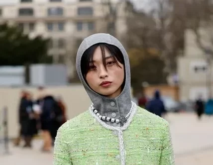 Yaqian Lan Donning winter 2025's most trending accessory- a knitted hood with a matching lime green tweed suit, Yaqian Lan brought a pop of colour to the Chanel show guestlist.