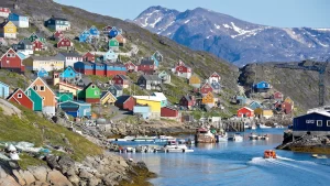 Colorful houses in Greenland on a port with snowy mountains in the background