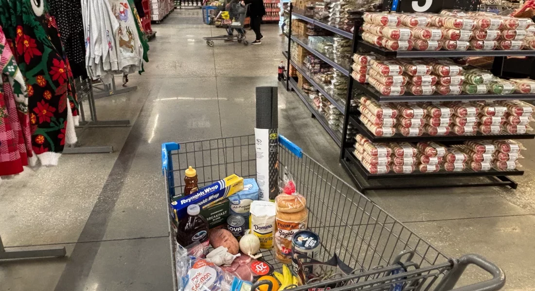 This photo features a shopping cart in a grocery store. The shopping cart is filled with various products.